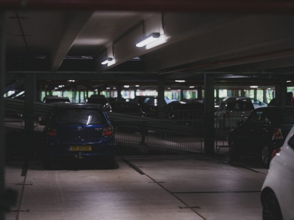 Cars are parked inside a dim, indoor parking garage.